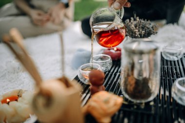 Parkta geleneksel çay seremonisi. Cam bardaklara kırmızı çay dök..