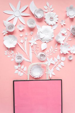 Kağıt torba farklı kağıt çiçek pembe bir arka plan üzerinde. Alışveriş. Üstten Görünüm. Düz yatıyordu