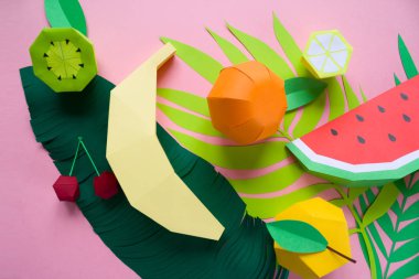 farklı tropikal yaprak kağıt üzerinde pembe bir arka plan ile egzotik meyve