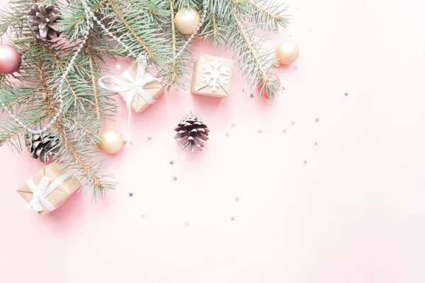Mutlu Noeller ve mutlu yeni yıl. Noel kartı yeşil çam dalları ve tatil nesne üzerinde soluk pembe bir arka plan ile şenlikli.