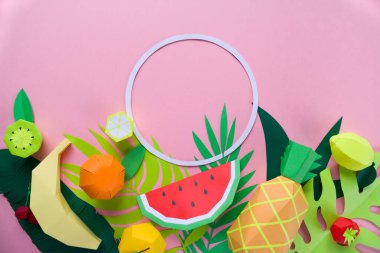 Farklı tropikal yaprak kağıt üzerinde pembe bir arka plan ile egzotik meyve ile yuvarlak çerçeve