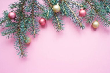 Mutlu Noeller ve mutlu yeni yıl. Noel kartı yeşil çam dalları ve tatil nesne üzerinde soluk pembe bir arka plan ile şenlikli.