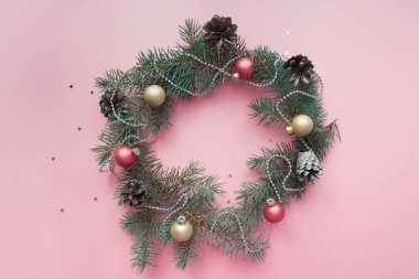 Mutlu Noeller ve mutlu yeni yıl. Yuvarlak neşeli Noel kartı yeşil çam dalları ve soluk pembe arka plan nesnesinde tatil çerçeve.