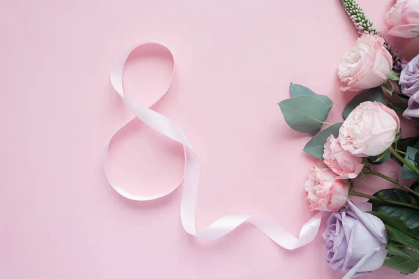 Mor ve pembe gül, beyaz Lisianthus ve değişik çiçek ve pembe bir arka plan üzerinde 8 şeklinde pembe kurdele çerçevesinde. Düz yatıyordu, en iyi görünümü