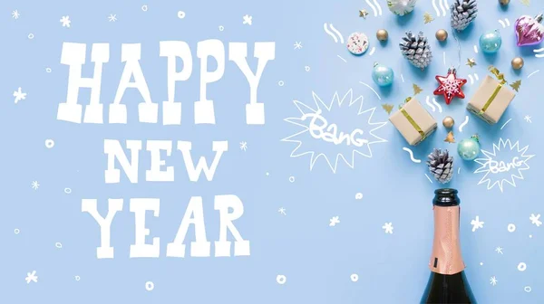 Lettering happy new year. Champagne bottle with different christmas decoration on blue background. Open champagne concept. Flat lay.