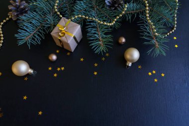 Mutlu Noeller ve mutlu yeni yıl. Noel kartı yeşil çam dalları ve tatil nesne üzerinde siyah arka plan ile şenlikli.