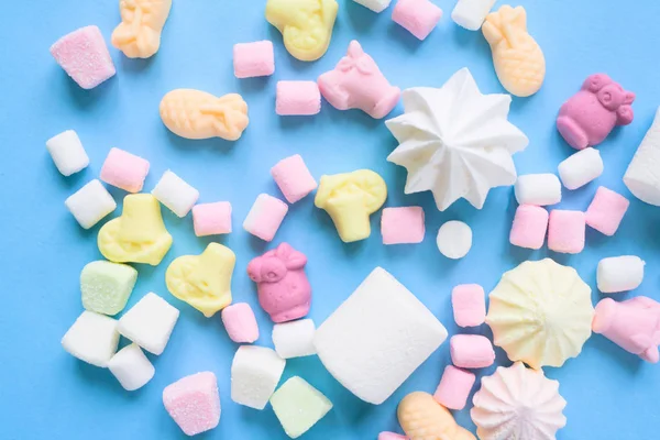 Pastel food set of colorful marshmallow on blue background. Dessert, minimalistic design.
