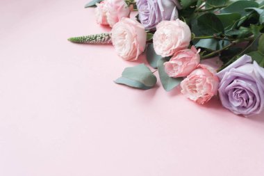 Mor ve pembe gül, beyaz Lisianthus ve değişik çiçek pembe bir arka plan üzerinde çerçeve. Düz yatıyordu, en iyi görünümü