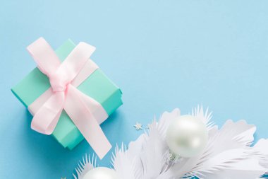 Mutlu Noeller ve mutlu yeni yıl. Kağıt ve tatil inci topları ve mavi arka plan üzerinde güzel Hediyelik Noel kartı şenlikli beyaz çam dalları ile yapılan.
