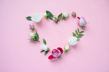 Kalpli çerçeve mor ve pembe gül, beyaz Lisianthus ve pembe bir arka plan üzerinde farklı çiçekler. Düz yatıyordu, en iyi görünümü