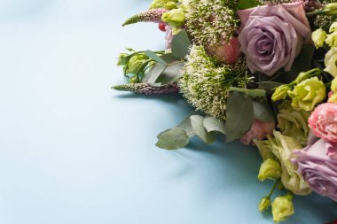 Mor ve pembe gül, beyaz Lisianthus ve değişik çiçek mavi zemin üzerine çerçeve. Düz yatıyordu, en iyi görünümü