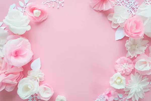 white and pink paper flowers on the pink background. Frame of flower