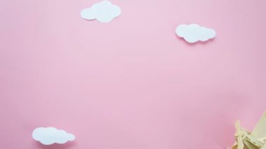 Sevgililer günün kutlu olsun. Eko Ahşap çocuk uçak kırmızı kalp ve kalp beyaz bulutlar şeklinde garland pembe bir arka plan üzerinde işaretler. Stop motion animasyon döngüsü.