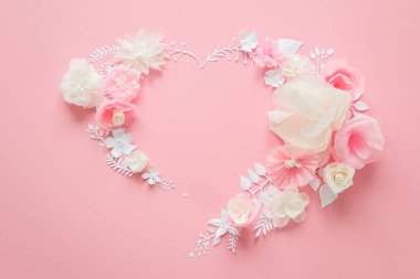 white and pink paper flowers on the pink background. Heart frame of flower