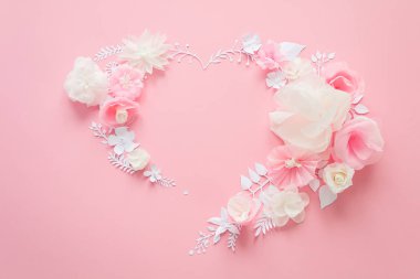 white and pink paper flowers on the pink background. Heart frame of flower