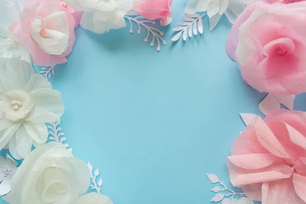 white and pink paper flowers on the pink background. Heart frame of flower