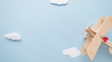 Sevgililer günün kutlu olsun. Eko Ahşap çocuk uçak kırmızı kalp ve kalp beyaz bulutlar şeklinde garland ile mavi bir arka plan üzerinde işaretler. Stop motion animasyon döngüsü.