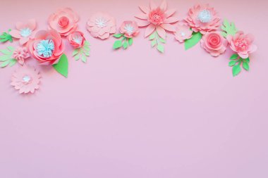 Delicate pink paper flowers on pink background. Summer concept