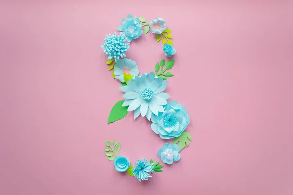 8 Mart Kadınlar günü kartı mavi kağıt çiçekler üzerinde pembe bir arka plan ile. Kağıttan kesilmiş.