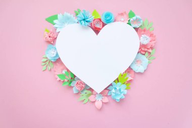 Kalpli çerçeve ile kağıt çiçekler pembe bir arka plan üzerinde yeşil yaprakları ile. Kağıttan kesilmiş. Sevgililer günü kavramı