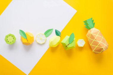 Meyve kağıttan yapılmış. Sarı arka plan. Yazmak için yer vardır. Tropics. Düz yatıyordu. Ananas, elma, limon, muz ve kivi. Sarı yaz konsepti