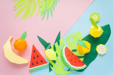 egzotik meyve trendy kağıda yapılmış mavi ve pembe bir arka plan ile yeşil tropikal yaprak