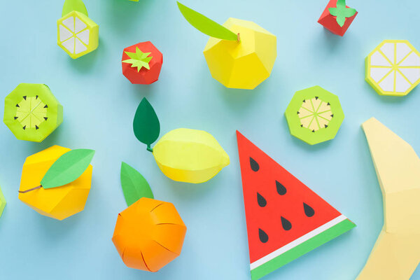 Fruit made of paper. Blue background. There's room for writing. Tropics. Flat lay. Watermelon, Apple, lemon, banana and kiwi. Yellow summer concept