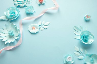 çerçeve mavi kağıt çiçek ve mavi arka plan üzerinde pembe kurdele ile.