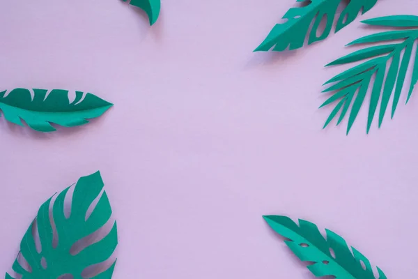 Hojas tropicales cortadas de papel sobre un fondo rosa . — Foto de Stock