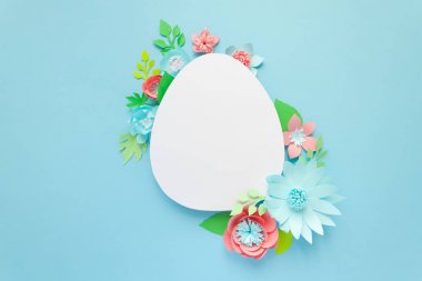 Mutlu paskalyalar. Kağıt üzerinde mavi arka plan Paskalya yumurtası yapılmış.
