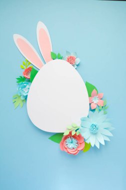 Mutlu paskalyalar. Kağıt üzerinde mavi arka plan Paskalya yumurtası yapılmış.