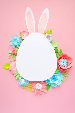 Mutlu paskalyalar. Kağıt üzerinde pembe bir arka plan Paskalya yumurtası yapılmış.