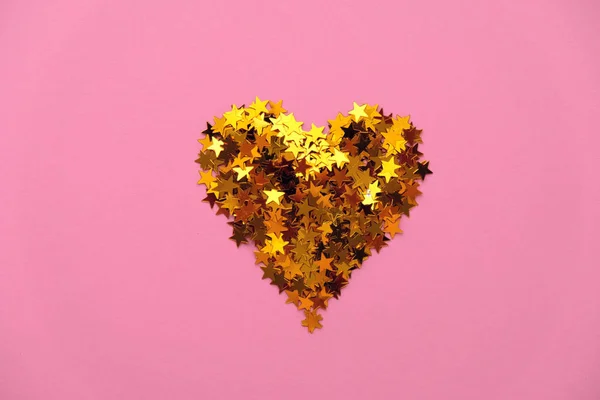 Paillettes dorate a forma di cuore su fondo rosa — Foto Stock