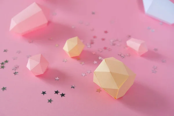 Polygonale Diamanten aus Papier auf rosa Hintergrund — Stockfoto