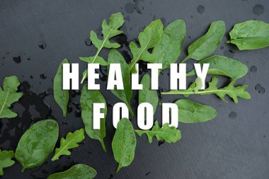 ispanak ve arugula su damlaları ile siyah arka plan üzerinde yaprakları