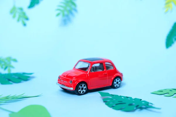 Pequeno brinquedo carro vermelho conduzido pelo verão — Fotografia de Stock