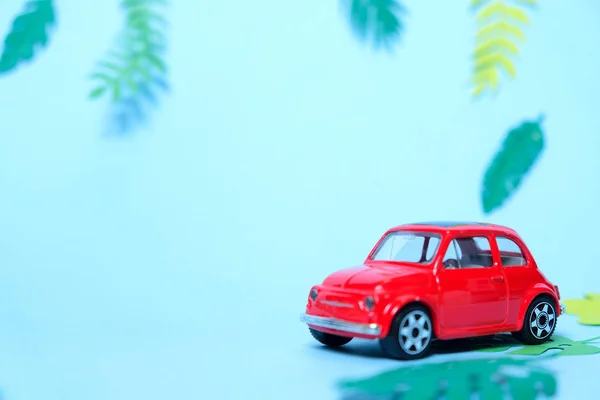 Pequeno brinquedo carro vermelho conduzido pelo verão — Fotografia de Stock