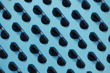 Pastel mavi arka plan üzerinde güneş gözlüğü desen. Trendy kavramı