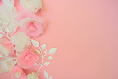 Pembe bir arka plan üzerinde beyaz kağıt çiçekler.