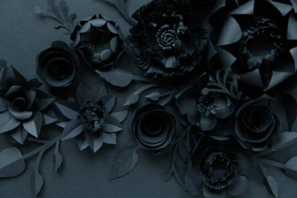 Black paper flowers on Black background. Cut from paper.