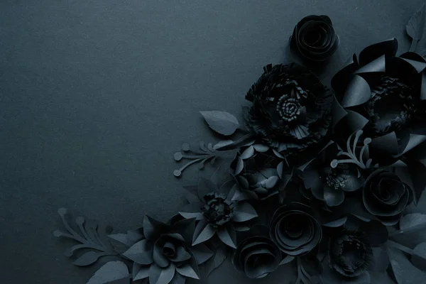 Black paper flowers on Black background. Cut from paper.