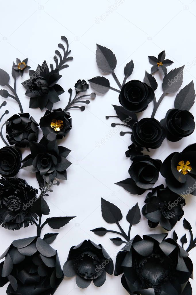 Black paper flowers on white background. Cut from paper.