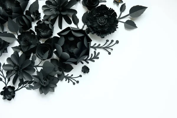 Black paper flowers on white background. Cut from paper.