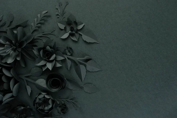 Black paper flowers on Black background. Cut from paper.