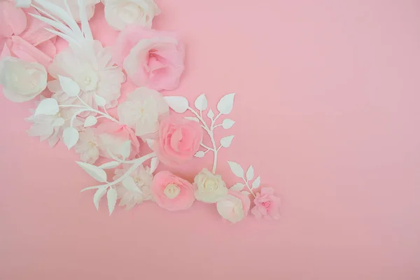 White paper flowers on pink background.