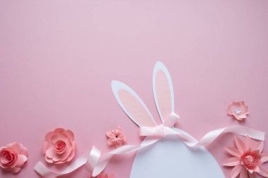 Mutlu paskalyalar. Kağıt üzerinde pembe bir arka plan Paskalya yumurtası yapılmış.