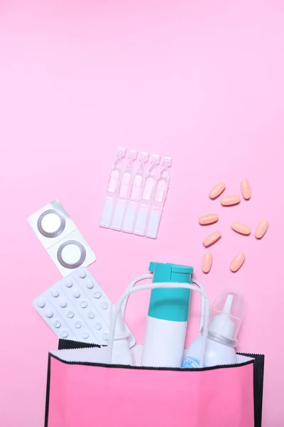 Холодный сезон, упаковка лекарств на розовом фоне . — стоковое фото