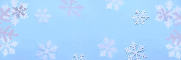 Zimowe tło. Białe płatki śniegu cięte z białego papieru na niebieskim tle. — Zdjęcie stockowe
