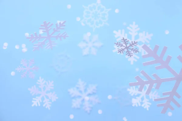 Sfondo invernale. Fiocchi di neve bianchi tagliati da carta bianca su uno sfondo blu . — Foto Stock