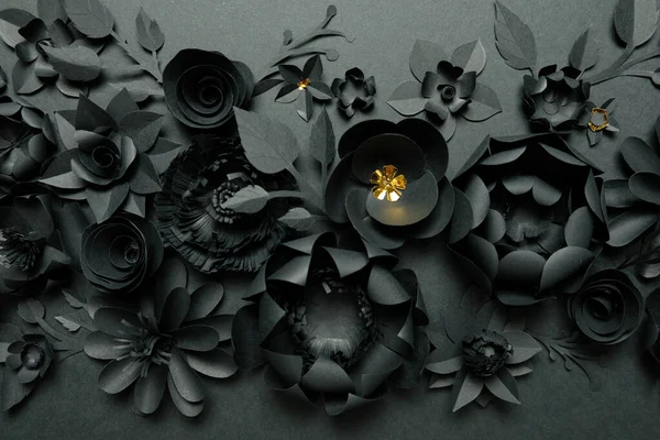 Black paper flowers on Black background. Cut from paper.